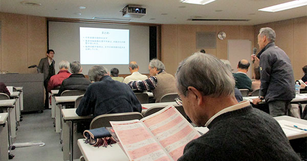 質問をする参加者と講演の様子