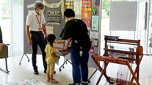 機織りコーナーの展示をのぞきこむ少女