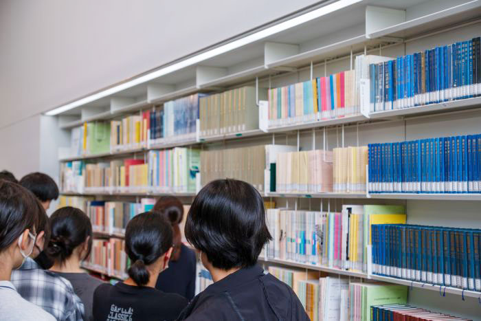 研究図書室で、熱心に本棚を見る公文国際学園中等部の皆さん